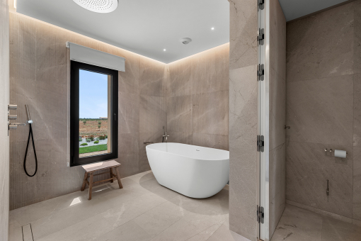 Lujoso baño principal con piedra natural y elegante bañera