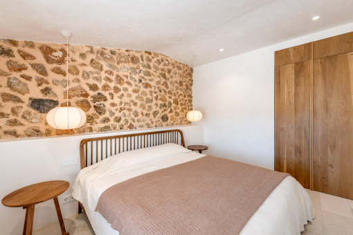Guest bedroom with stone wall and warm lighting
