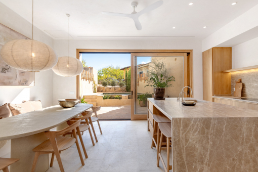 Open-plan kitchen with stone island and view into the living room