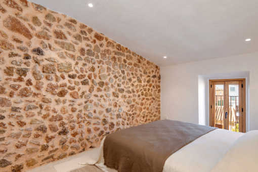 Guest bedroom with stone wall and warm lighting