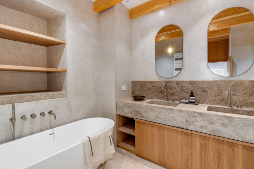High-end en-suite bathroom with natural stone and freestanding bathtub – timeless design and comfort