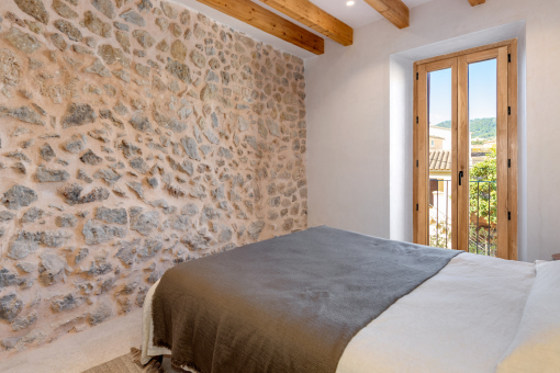 Guest bedroom with stone wall and warm lighting