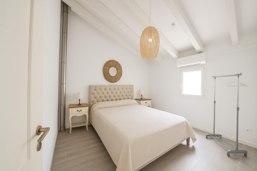 Elegant master bedroom with natural light and large mirror