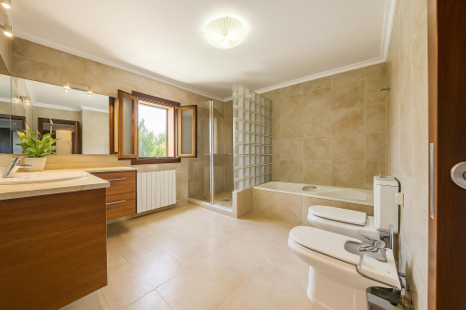 Baño elegante con bañera, bidé y luz natural en finca rústica cerca de Alcúdia