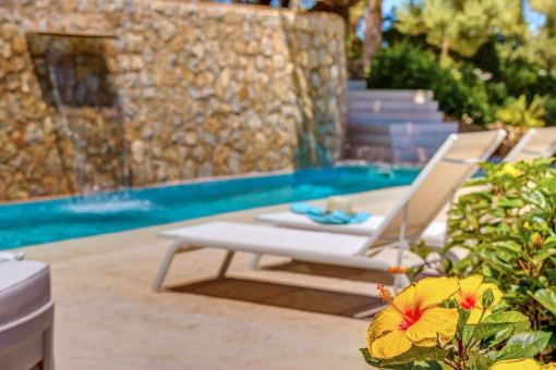 Outdoor area with pool and comfortable sun loungers