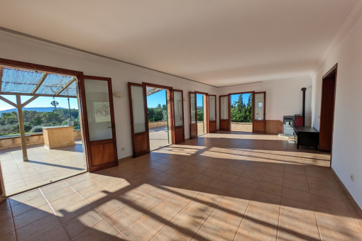 Spacious, light-flooded living area with many windows and doors opening to the terrace