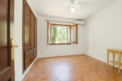 Habitación vacía con armario de madera y ventana