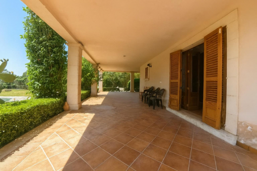 Amplia terraza sombreada con jardín y piscina