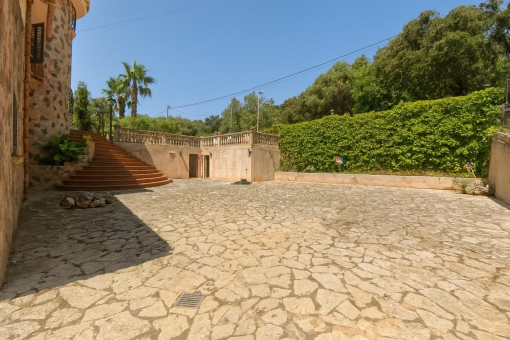 Amplio patio pavimentado con jardín