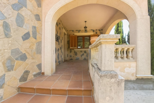 Patio de piedra con arco y balaustrada