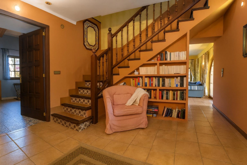 Cozy ground floor hall with staircase and bookshelf