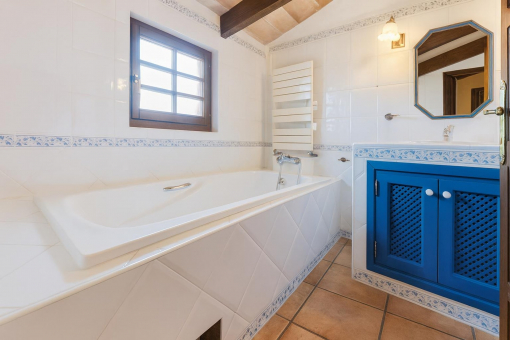 Bathroom with bathtub and blue cabinet