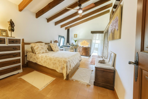 Dormitorio luminoso con vigas en el techo