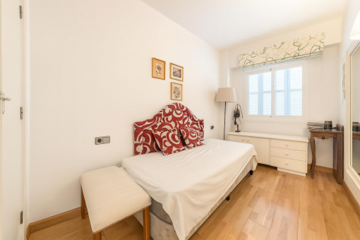 Kleines Schlafzimmer mit Fenster und Holzboden