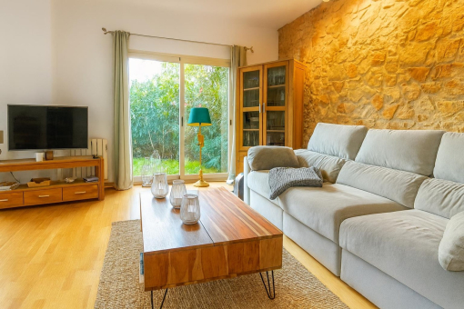 Sala de estar acogedora con pared de piedra