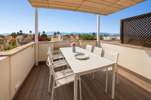 Terraza en la azotea con mesa y sillas cubierta