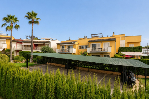 Plazas de aparcamiento al aire libre cubiertas con vista al jardín