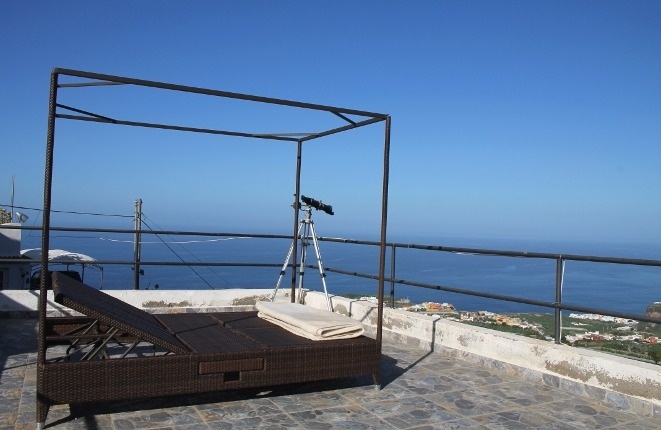 Terrace with sunbathing chairs and telescope