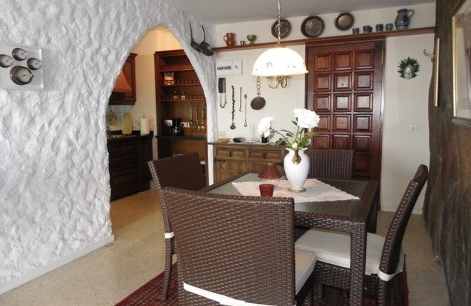 Dining area with the fitted kitchen and a pantry behind a stylish arch structure